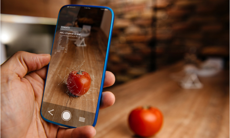 人工知能をスマートフォンで使い、食品を認識する拡張現実アプリを使う男性